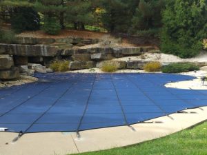 image showing a standard mesh pool cover installed on a customers inground swimming pool