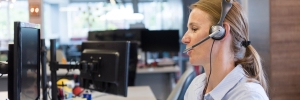 customer service rep on phone with a smile and headset waiting for calls to help customers figure out the best safety pool cover for kids and dogs for each customer
