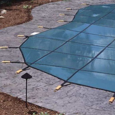 pool-safety-cover-with-strong-durable-straps-and-anchors-safe-for-kids-and-dogs close up image of a pool safety cover showing strong and durable anchors which are important for the safety of kids and dogs